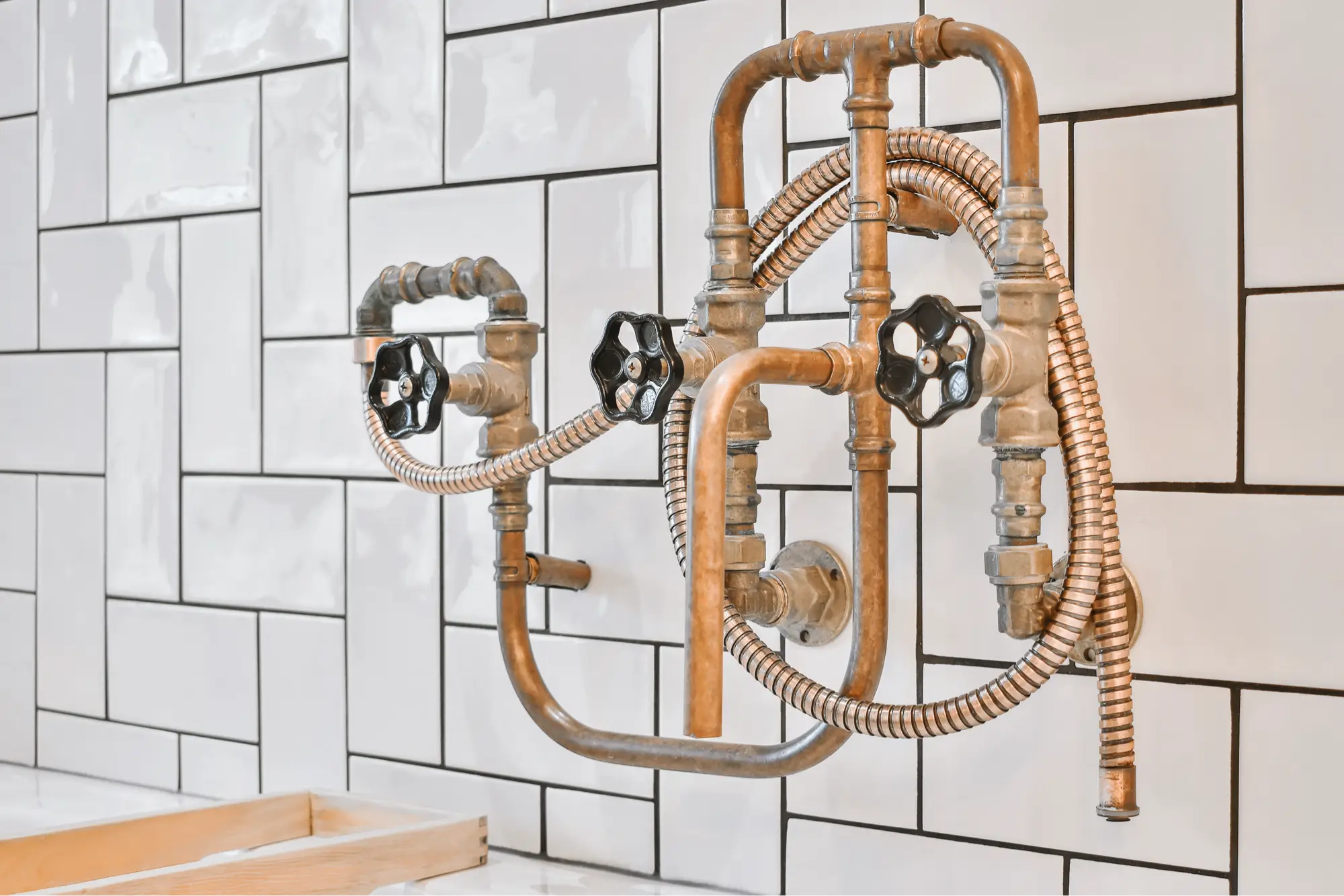Decorative exposed bathroom plumbing fixture mounted on tiled wall